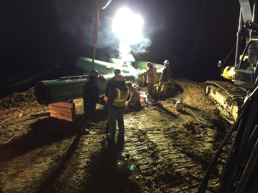 Blue and Gold crew working at night under jobsite lighting